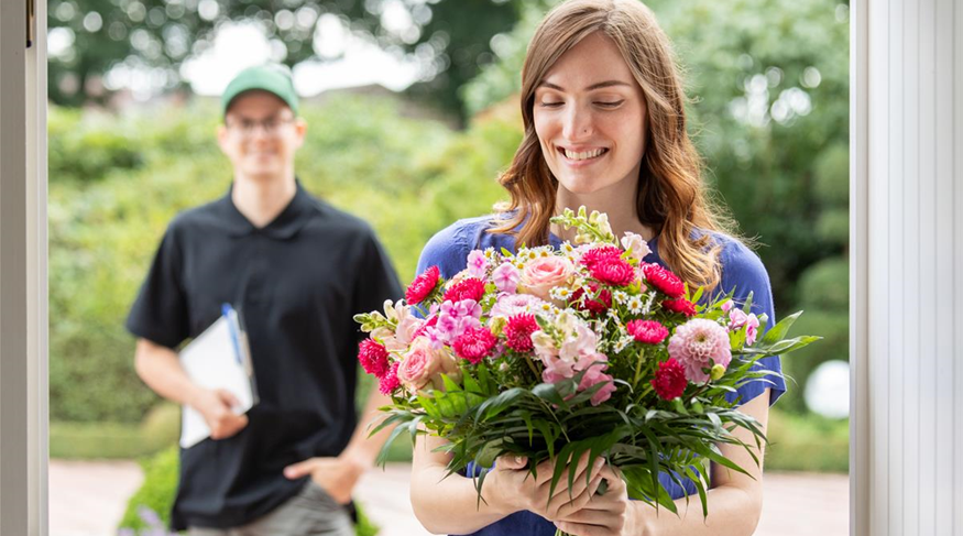 Lieferservice - Frau erhält Blumenpräsent (GS670120.jpg)